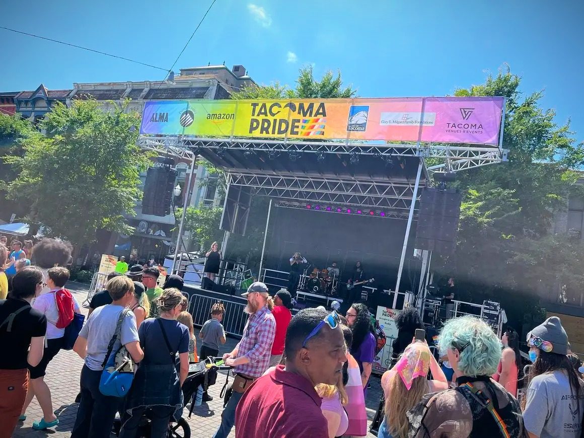Tacoma Pride sponsor banners across a mobile stage roof